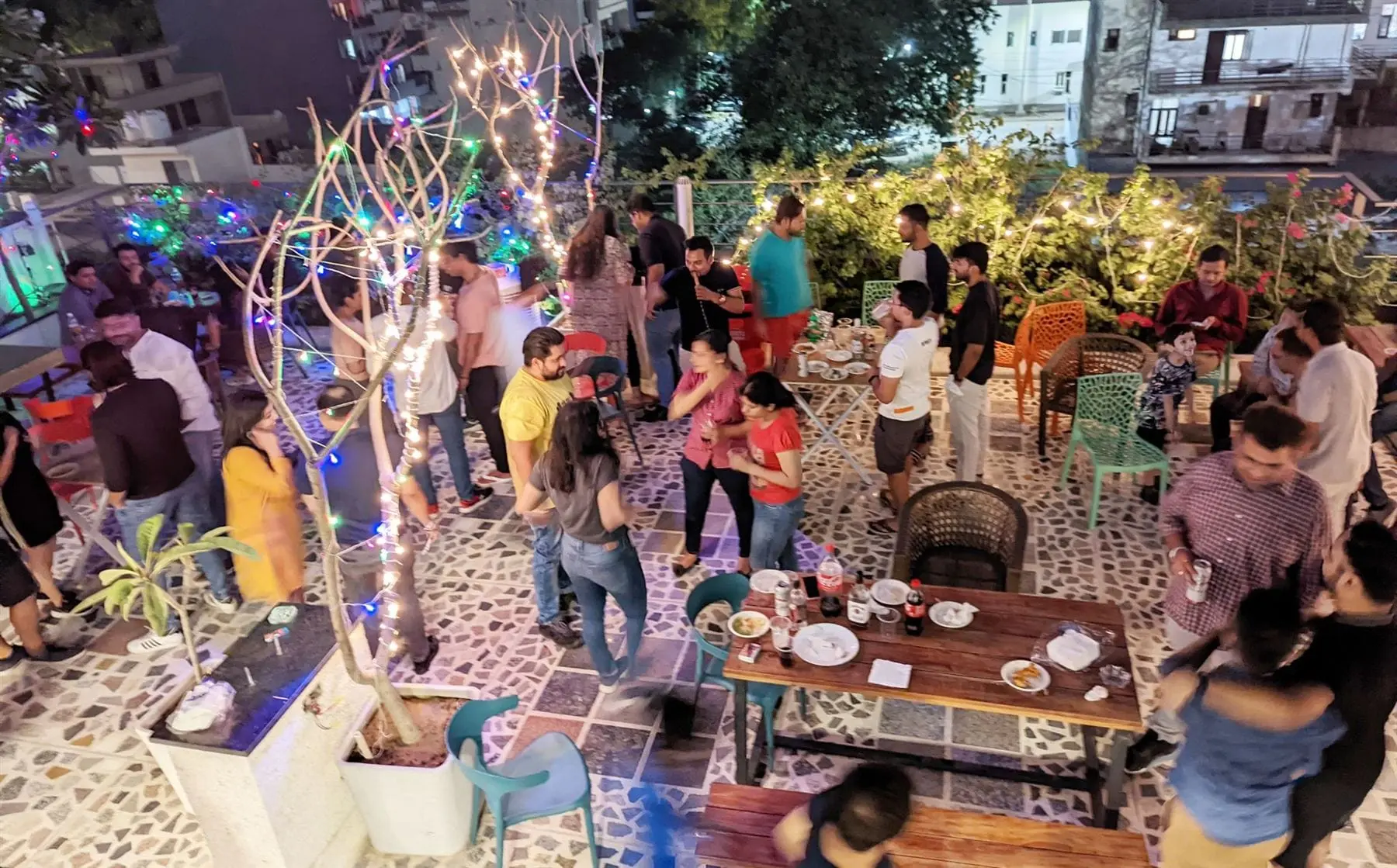 Communrs at a string-lit rooftop party at Commune Prime