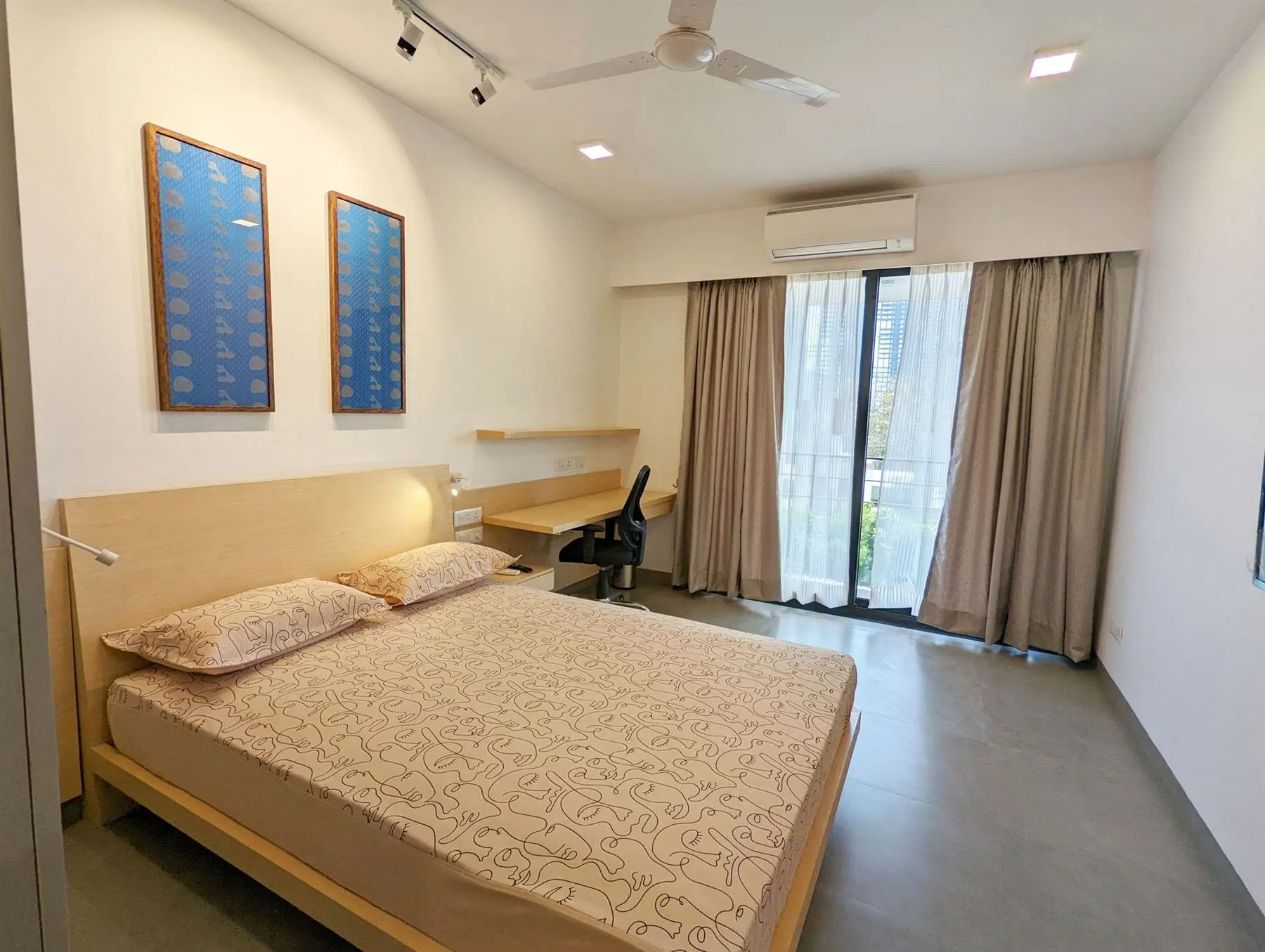 A private room at Commune Prime with a queen bed and floor-to-ceiling windows