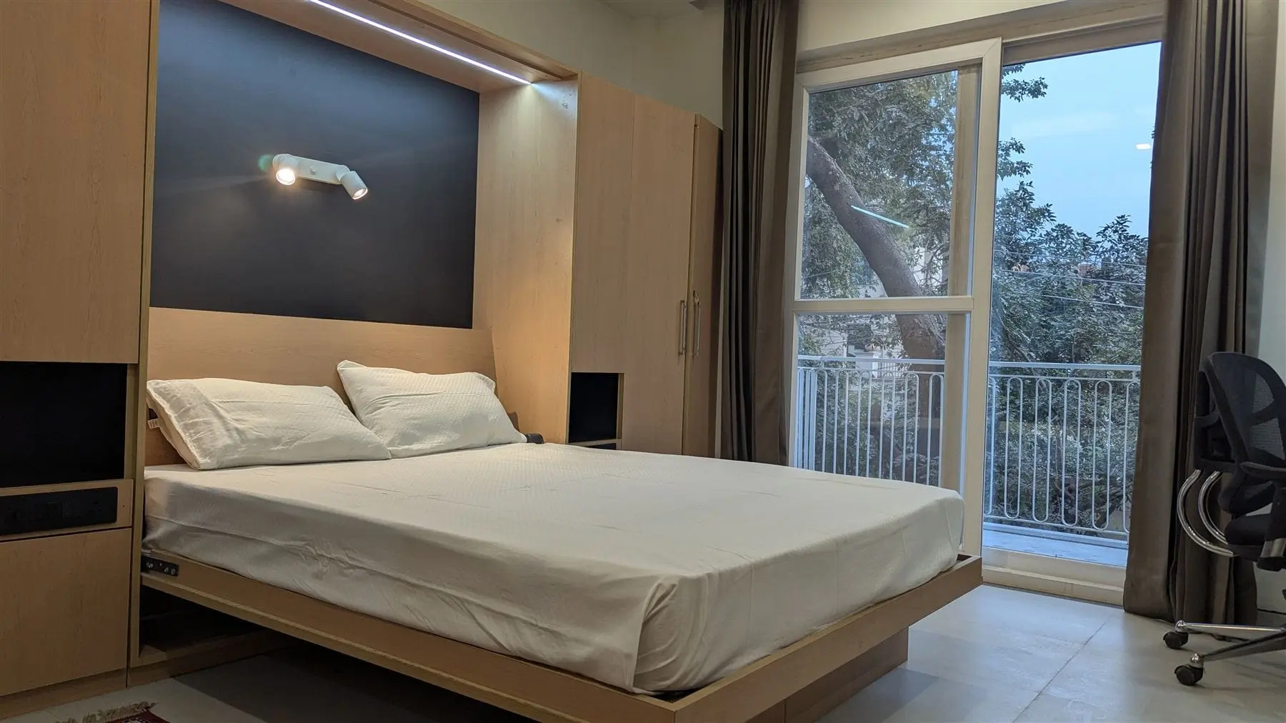 A studio at Commune Siris with the Murphy bed down and balcony doors