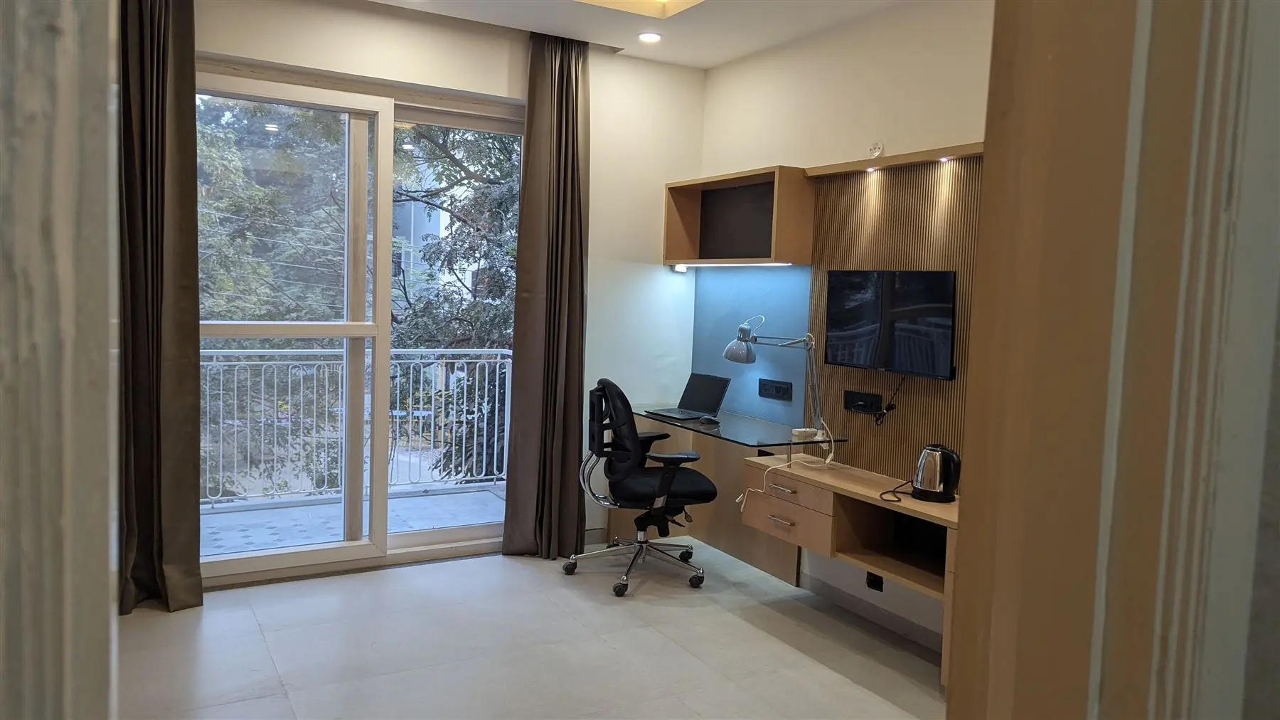 Work desk, TV and balcony in a Commune Siris studio
