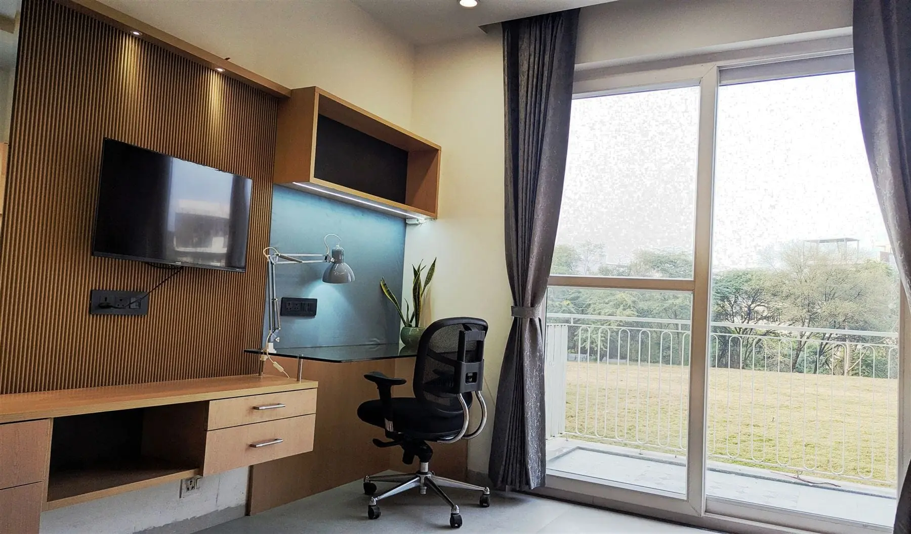 A Commune Siris studio with a work desk looking out over a lawn