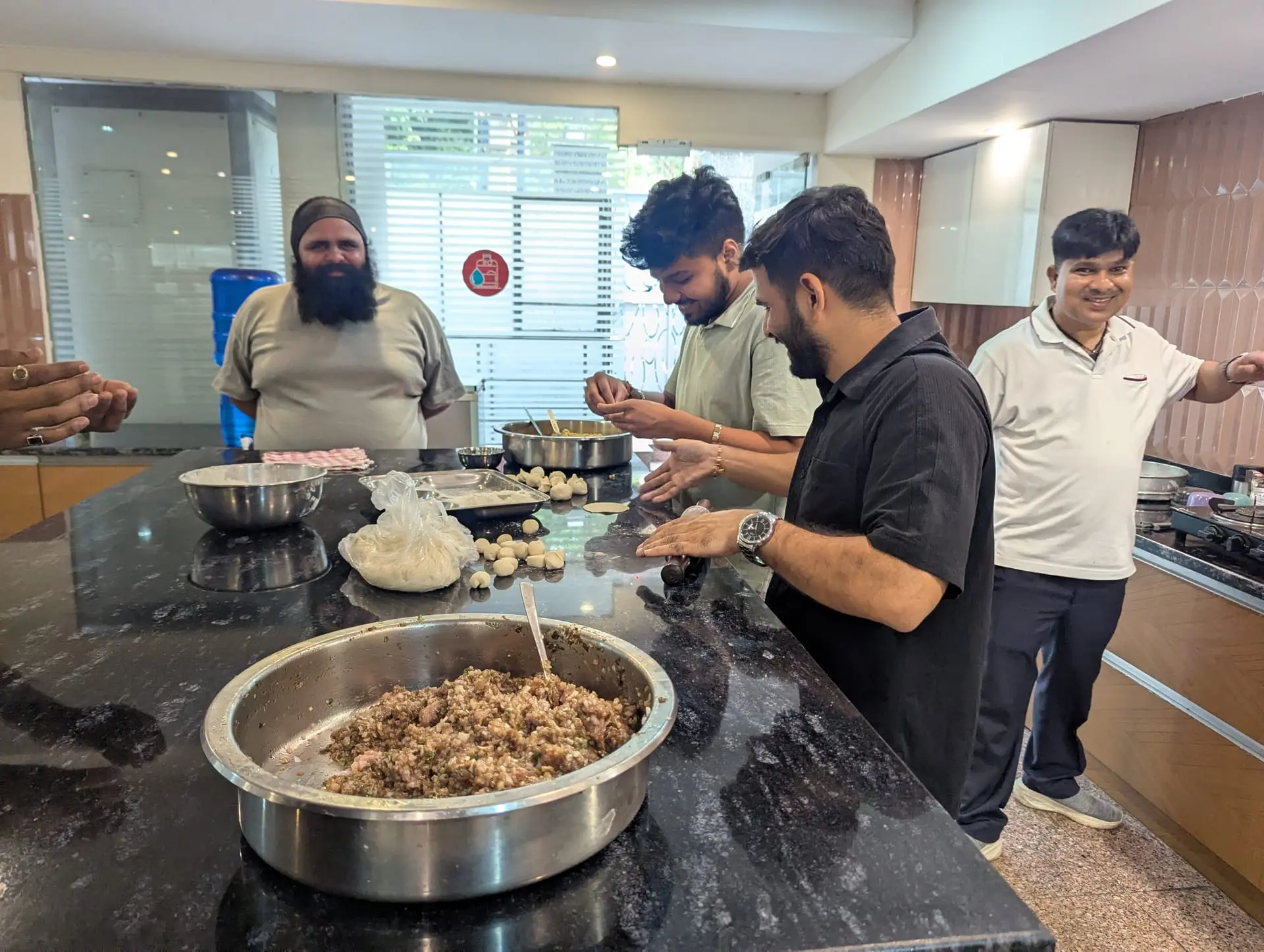 Communrs preparing a large bowl of momo filling in the community kitchen