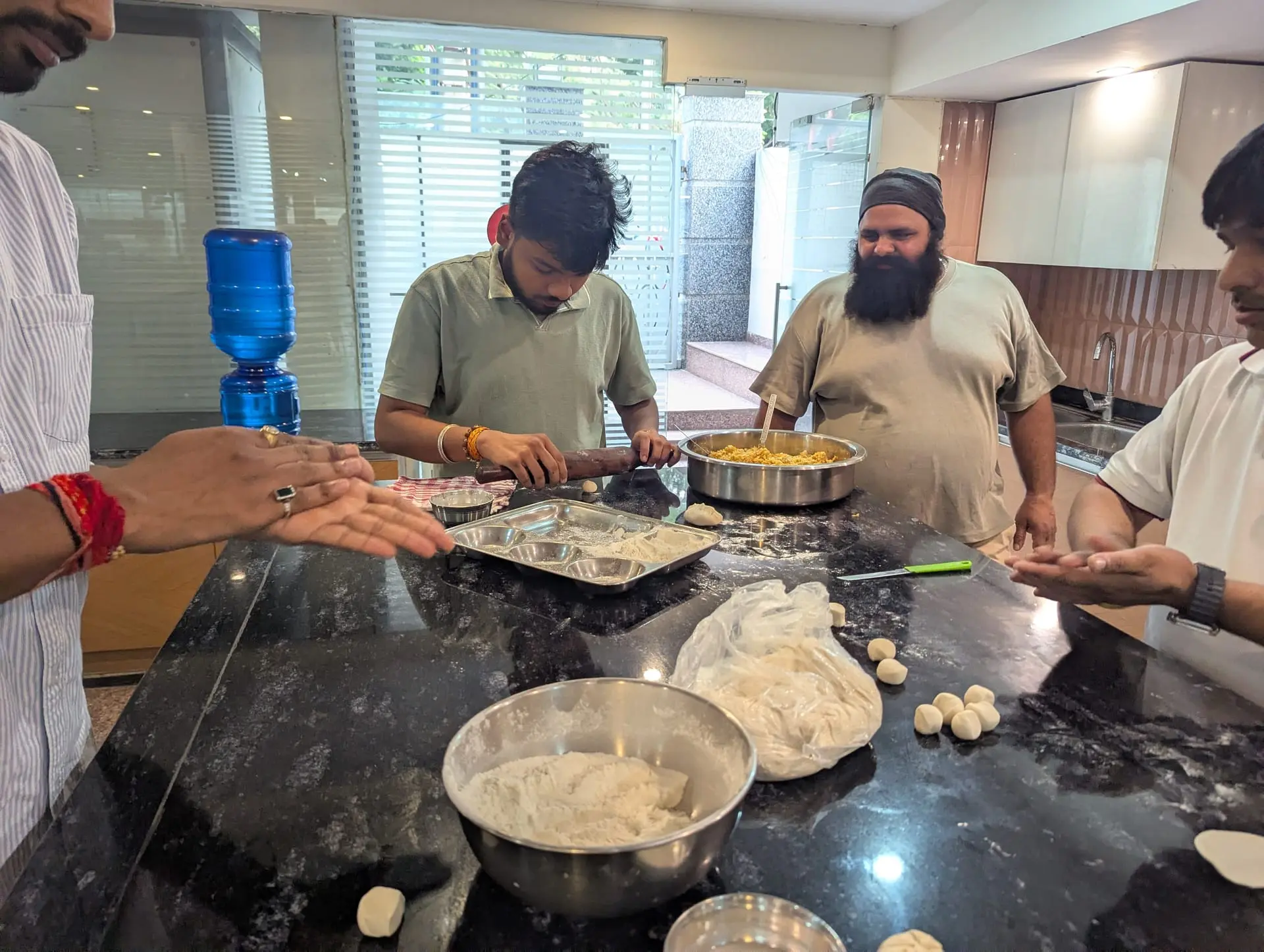 Communrs rolling and filling wrappers in the community kitchen