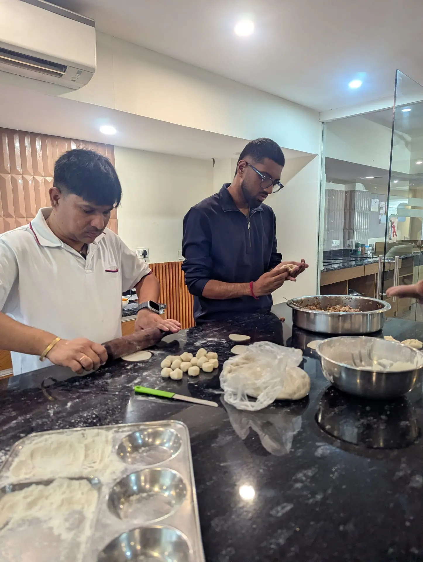 Two Communrs filling momos in the community kitchen