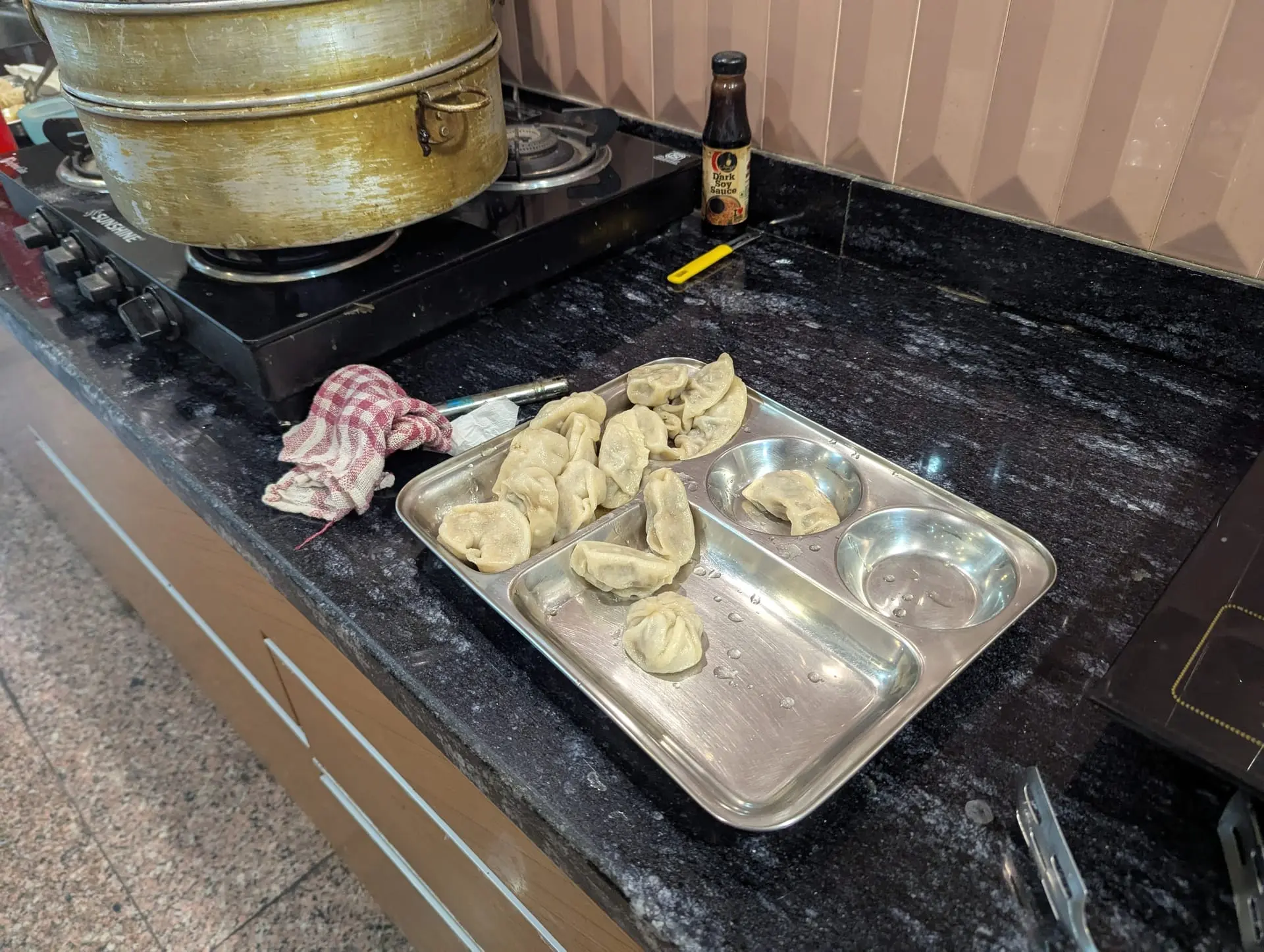 A tray of pleated momos ready for the steamer