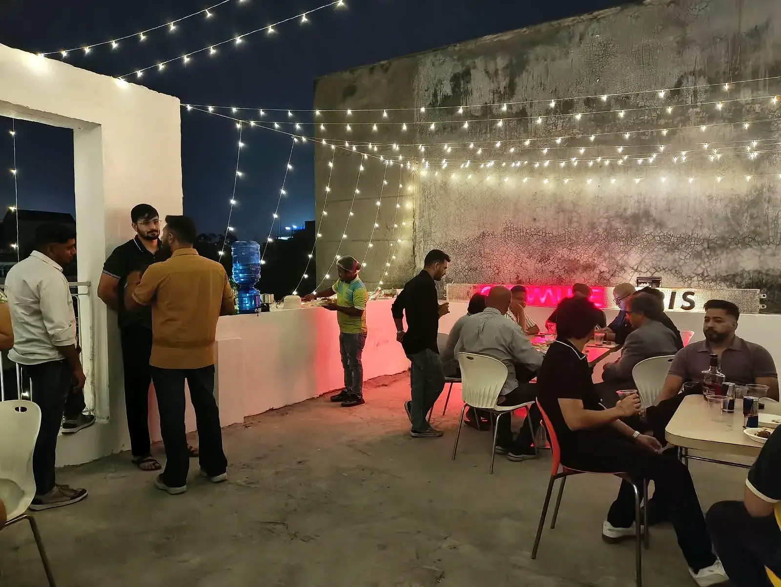 The drinks and food counter, with Communrs helping themselves