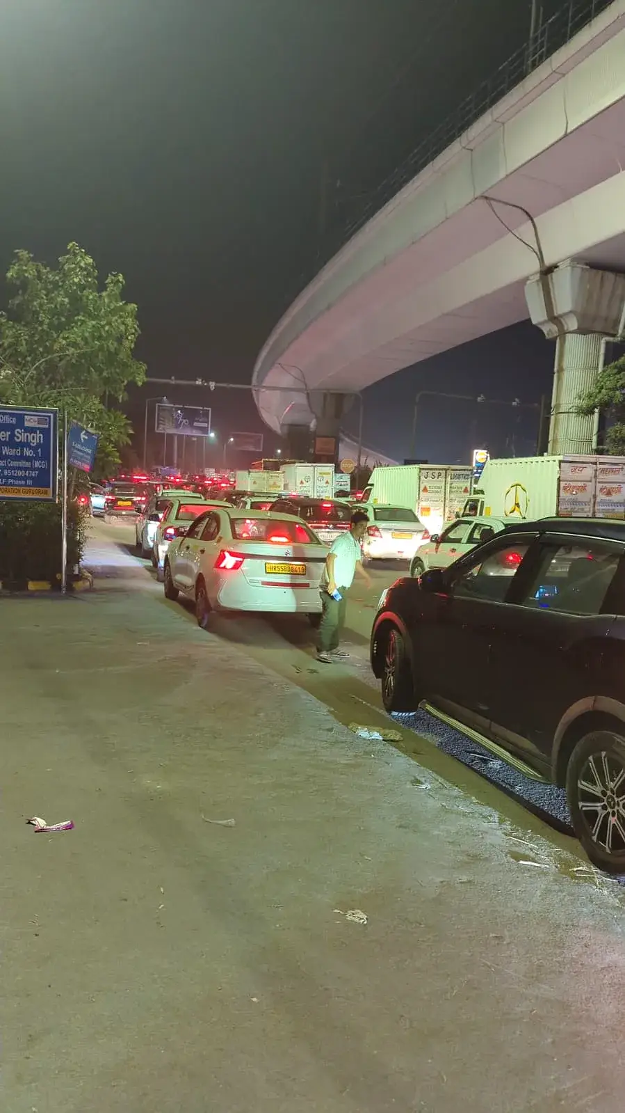 Traffic at a standstill under a flyover on the way to the party, cars backed up in the dark
