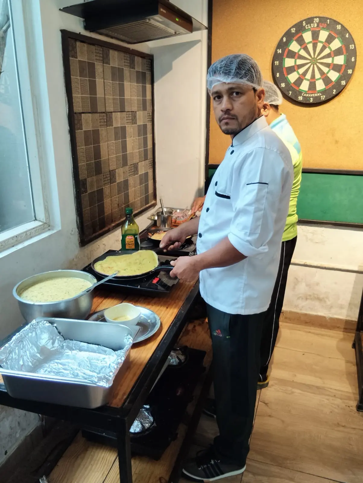 A chef making a fresh batch at the breakfast counter