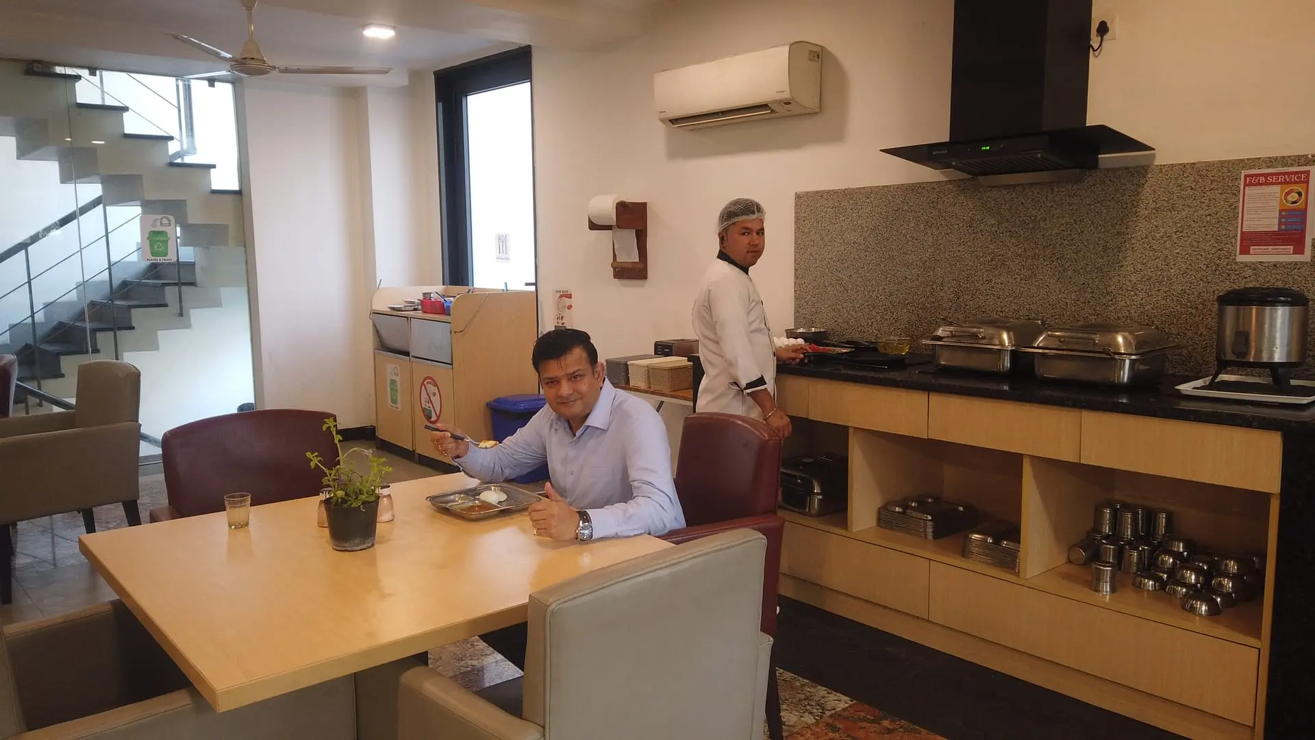 A resident at breakfast while a chef cooks at the live counter
