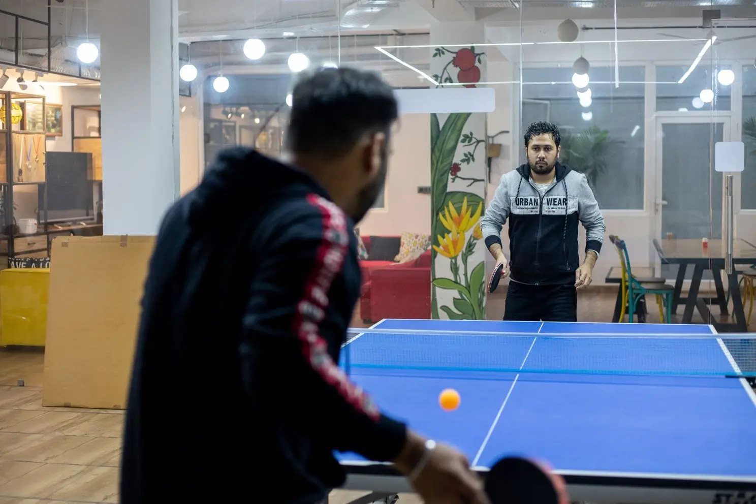 Two Communrs mid-rally at the table tennis table at Commune Greenwood