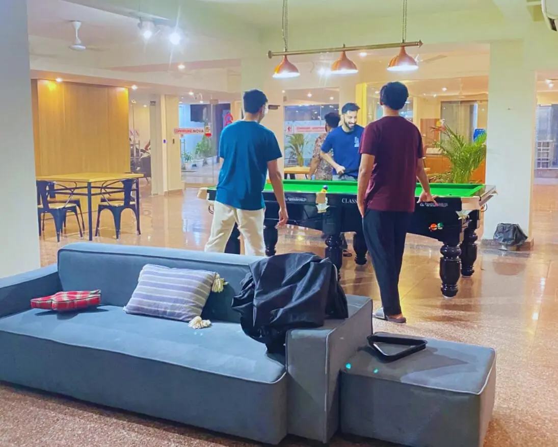 Communrs playing pool in the lounge at Commune Nova