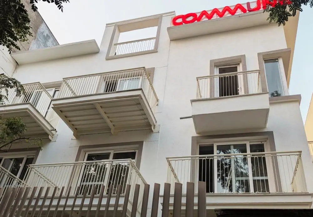 The front of Commune Siris, with the Commune sign on the roof
