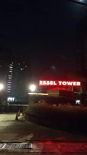 The lit Essel Tower sign at the entrance at night