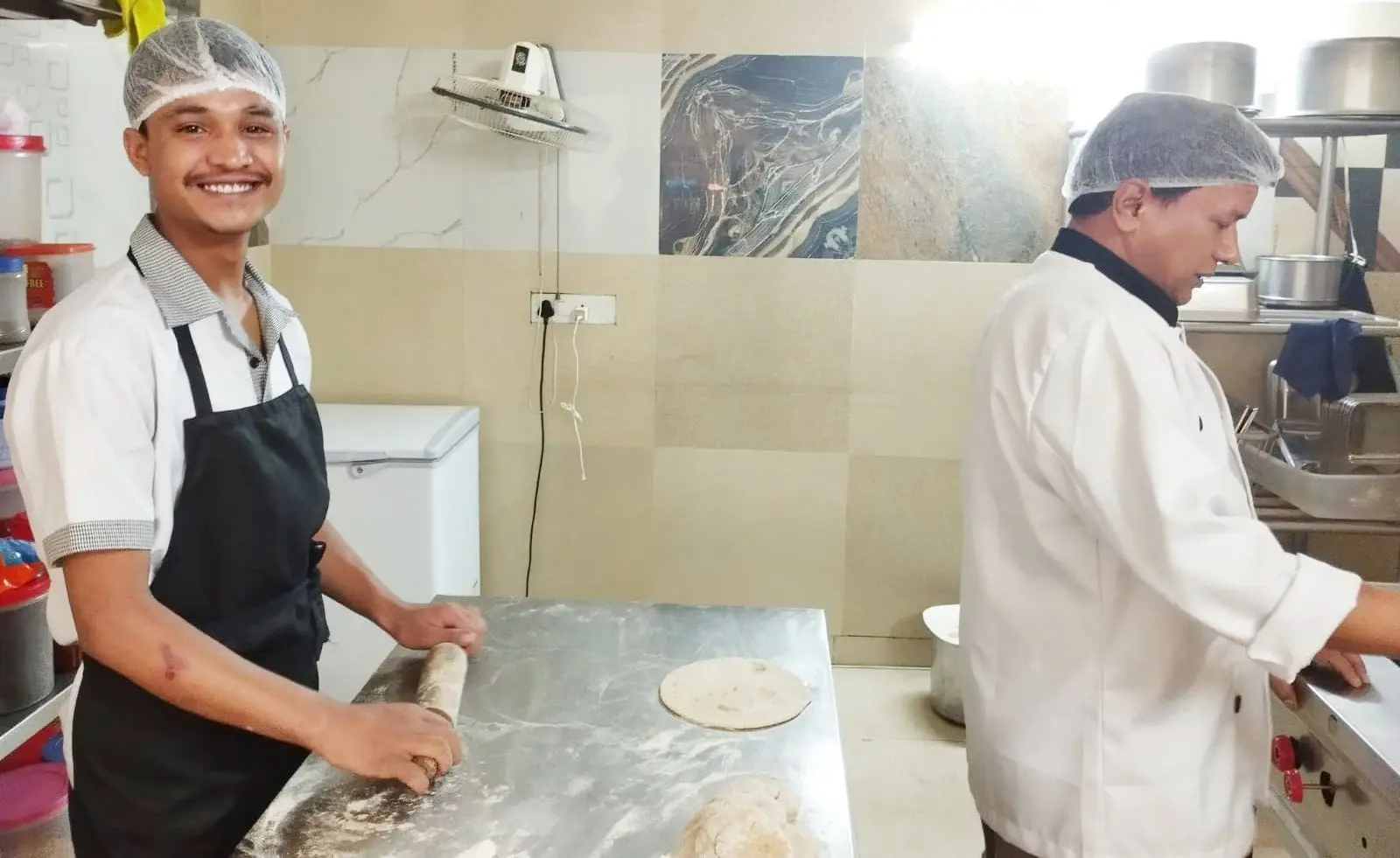 Commune chefs rolling rotis in the kitchen